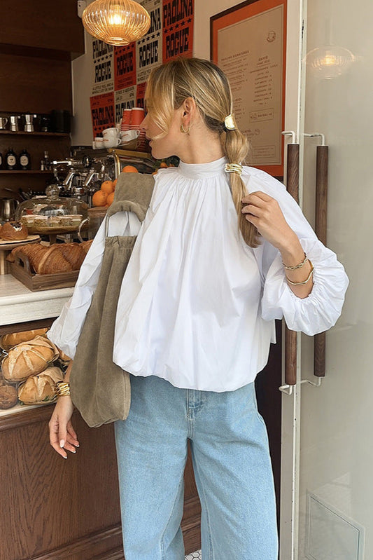 Blouse oversize style nordique blanche portée avec un jean bleu clair concentré sur la blouse