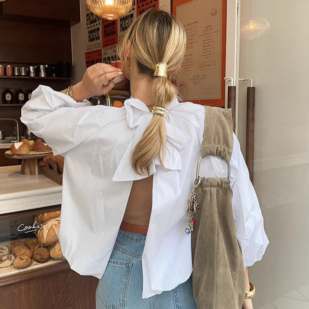 Blouse oversize style nordique blanche vue de dos avec dos ouvert et nœud portée avec jean bleu