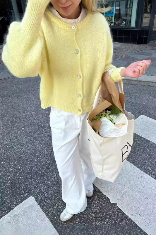 Cardigan doux look clean girl jaune pastel porté avec pantalon blanc et sac de courses My Store