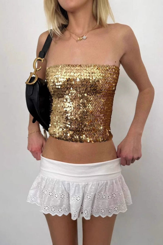 Haut style nordique chic doré à paillettes porté avec jupe blanche volantée en dentelle