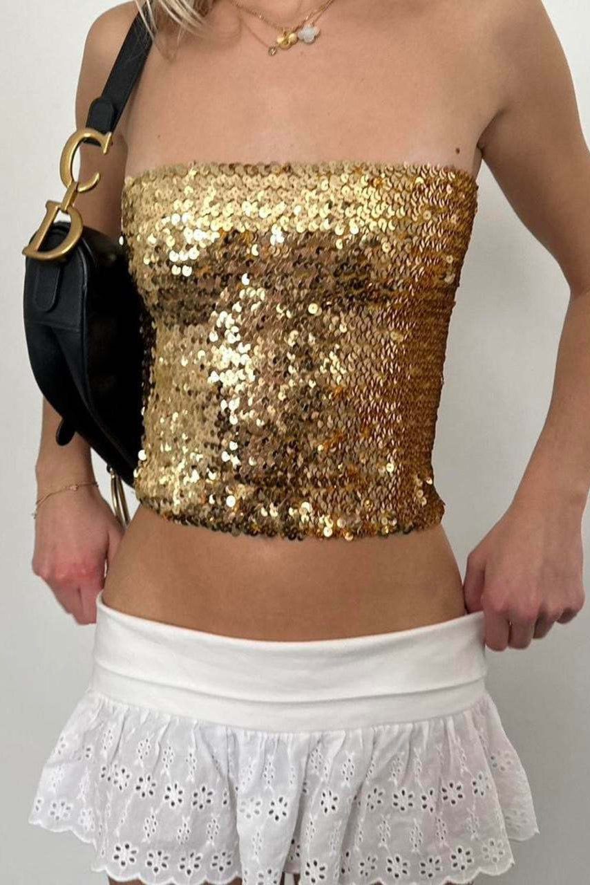 haut style nordique chic doré à sequins porté avec jupe blanche ajourée et sac noir
