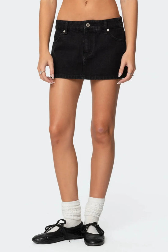 Femme portant une jupe courte jean scandinave noire avec chaussures plates et chaussettes blanches