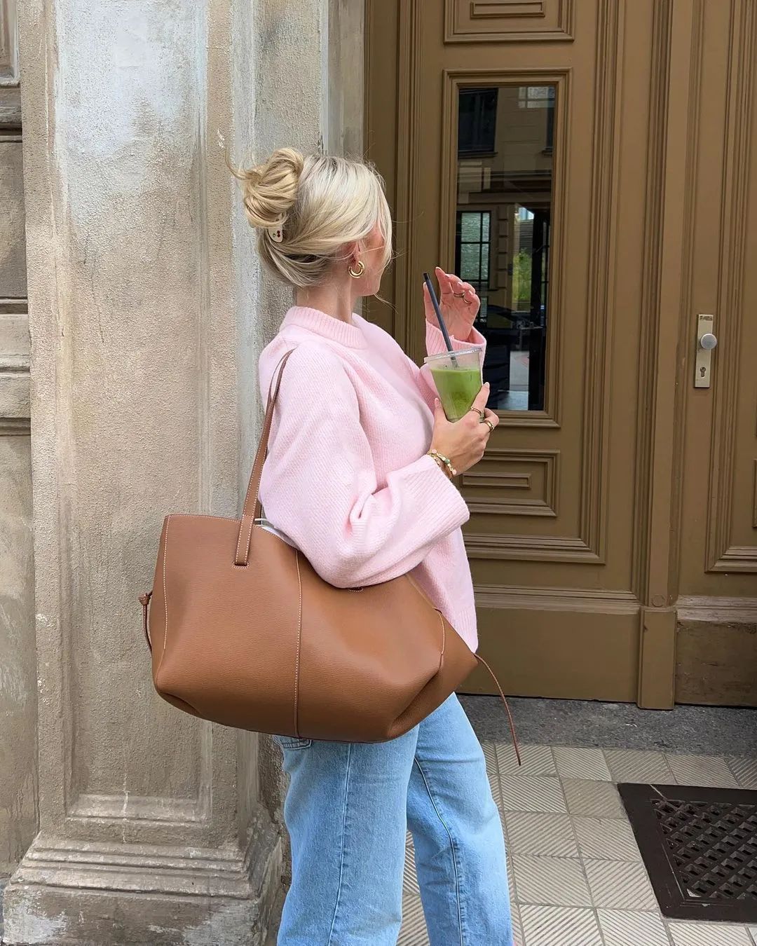 Look clean girl cardigan rose porté par une femme avec un sac marron et un jean bleu