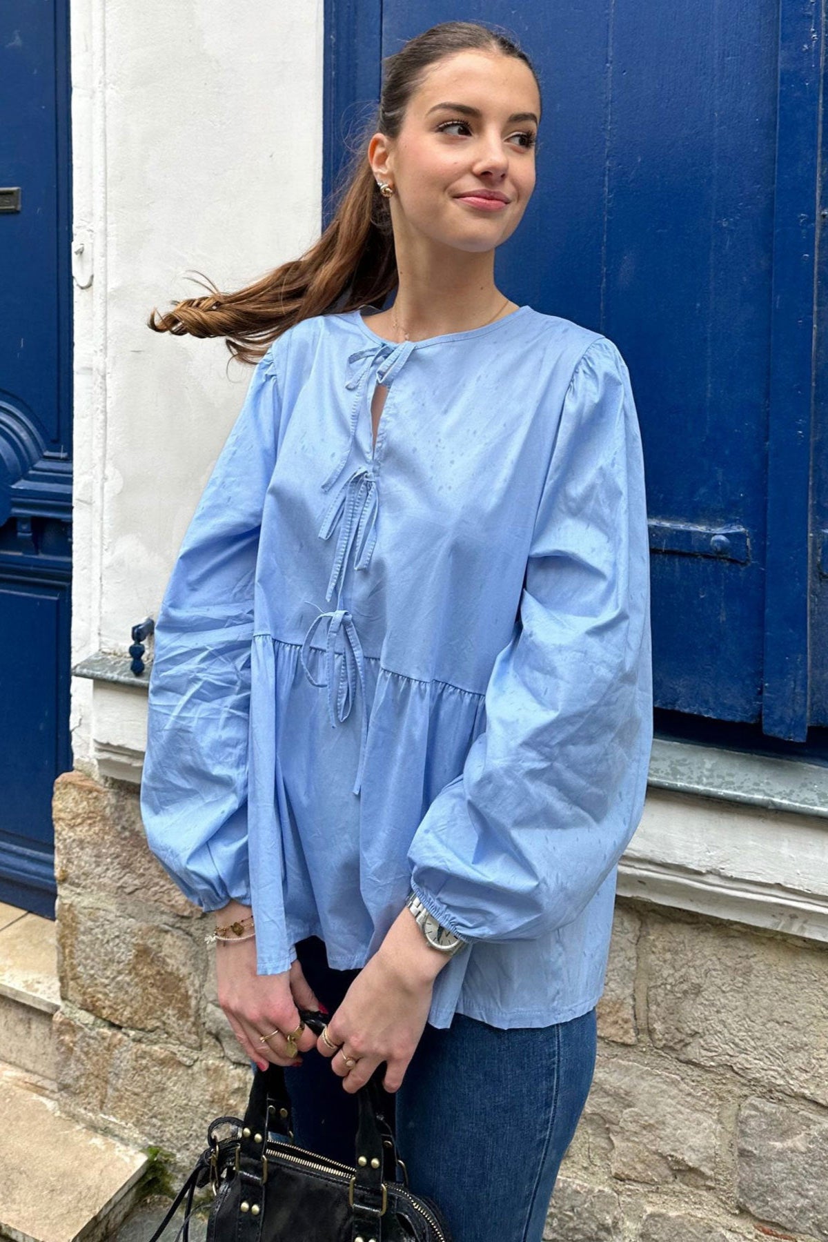 Femme portant un haut scandinave femme tendance bleu clair à manches bouffantes et détail noué