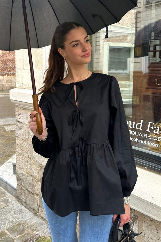 Femme portant un haut scandinave femme tendance noir à manches longues avec un parapluie