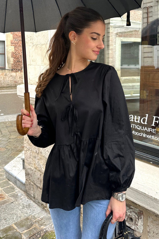 Femme portant un haut scandinave femme tendance noir avec manches bouffantes et nœuds décoratifs