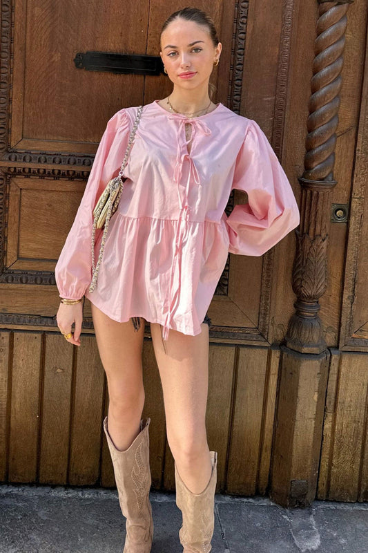 Haut scandinave femme tendance rose à manches longues et coupe ample porté avec bottes beige