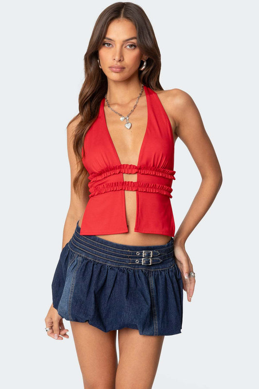 Top rouge à col en V profond porté avec une mini jupe style scandinave en jean bleu