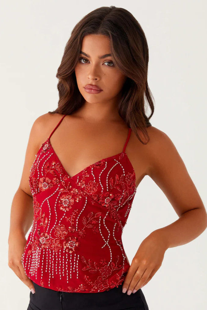 Femme portant un haut bleu style ibiza rouge brodé avec fines bretelles
