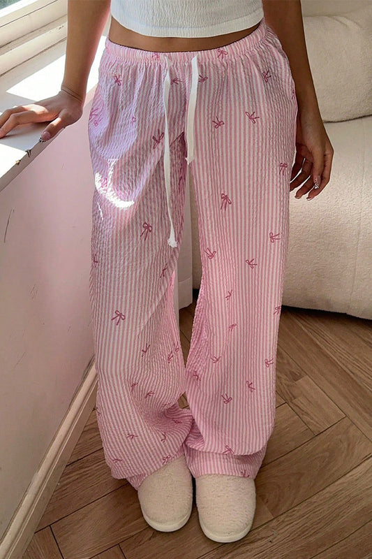 Femme portant un pantalon scandinave style rose à rayures avec motifs et cordon de serrage blanc