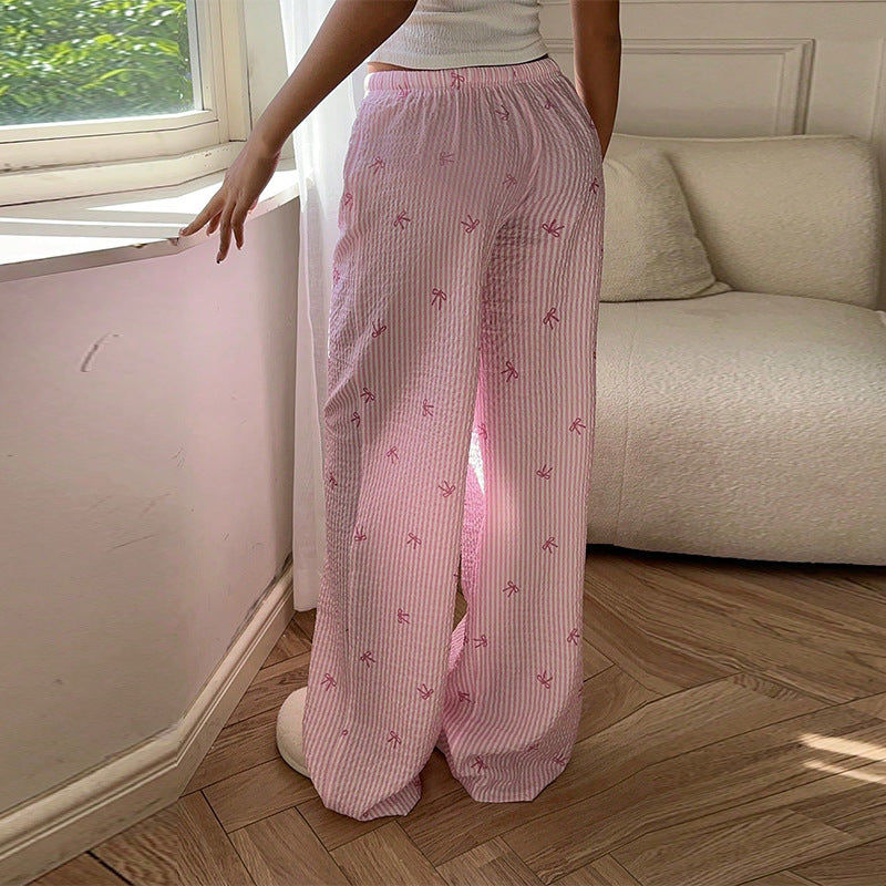 Pantalon scandinave style rose à rayures blanches porté avec un haut blanc dans un salon lumineux
