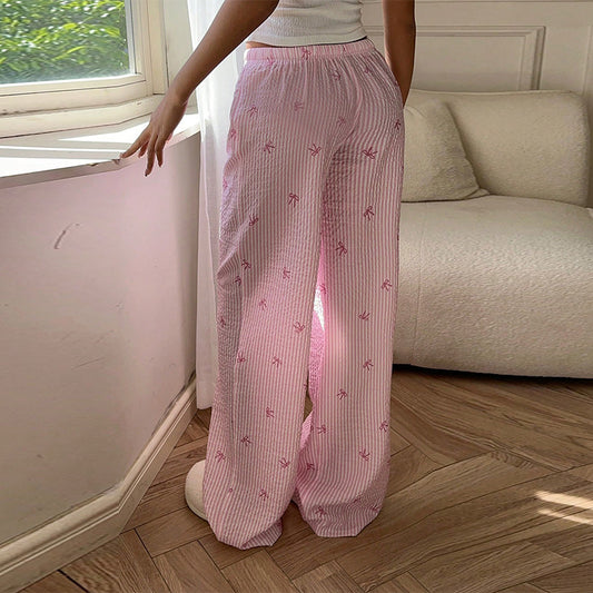 Pantalon scandinave style rose à rayures blanches porté avec un haut blanc dans un salon lumineux