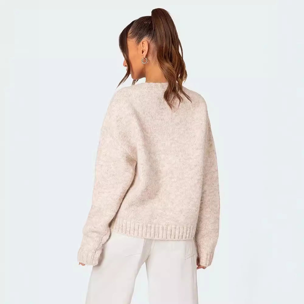 Pull Greekia motif drapeau grec beige porté de dos par femme avec pantalon blanc