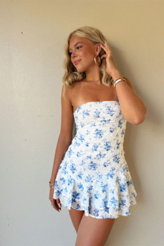 Robe courte bleu fleurie stockholm style avec bretelles et jupe volante portée par une femme blonde