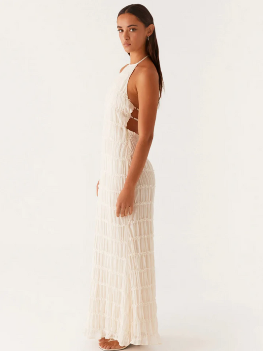Modèle féminin portant une robe élégante soirée jaune longue avec détails texturés et décolleté dos nu