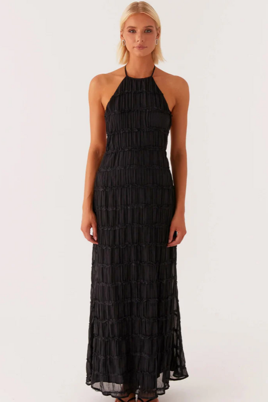 Robe longue noire élégante avec dos nu portée par modèle, contraste avec robe élégante soirée jaune