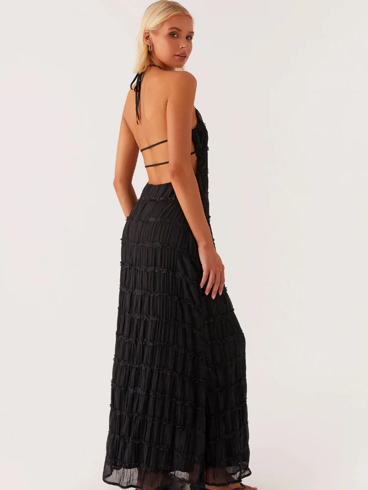 Femme portant une robe élégante soirée jaune noire longue dos nu avec détails en tissu texturé