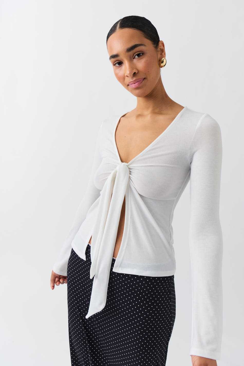 Femme portant un t-shirt style Stockholm pour femme blanc à manches longues avec nœud devant