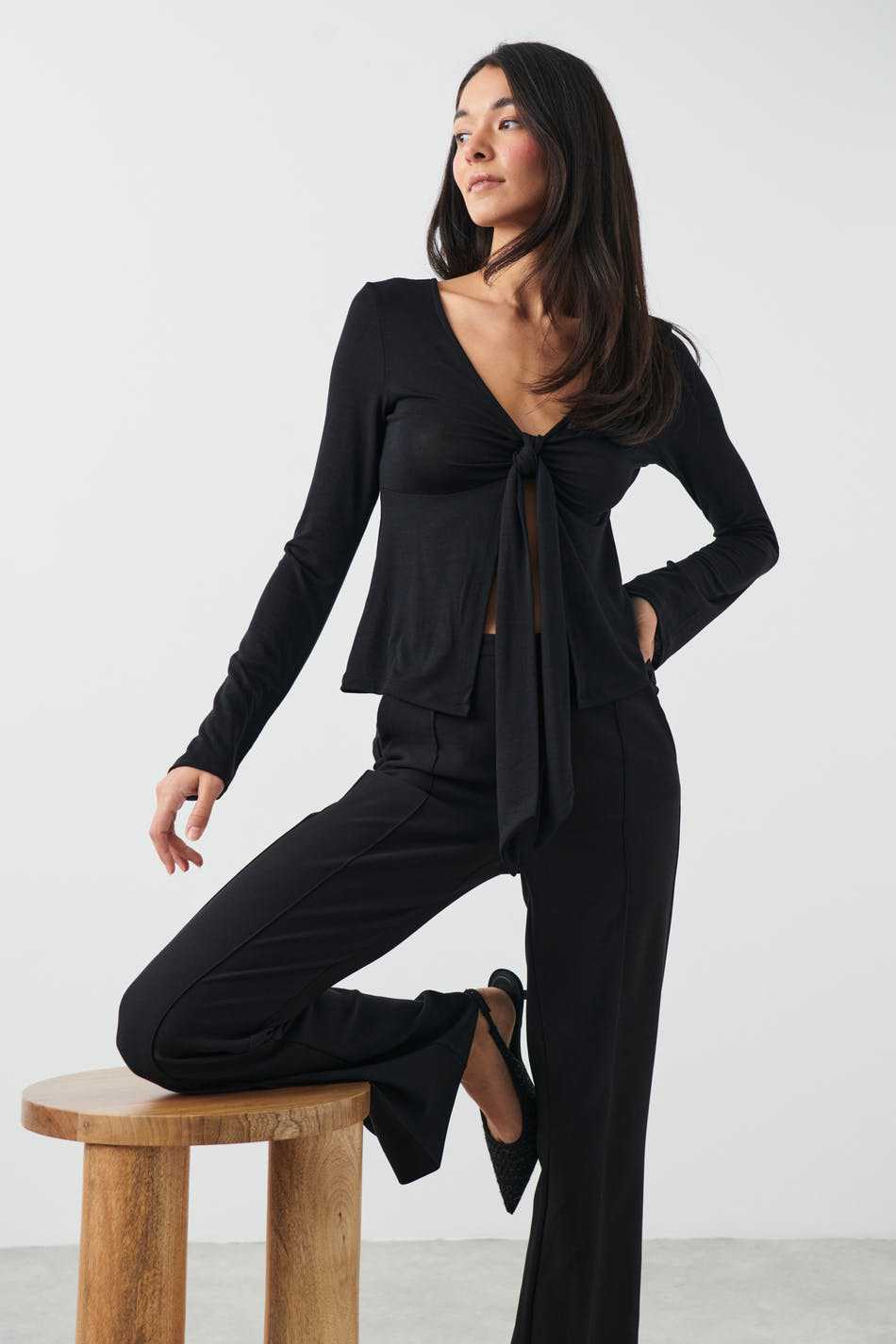 T-shirt style Stockholm pour femme noir à manches longues avec noeud devant porté avec pantalon assorti