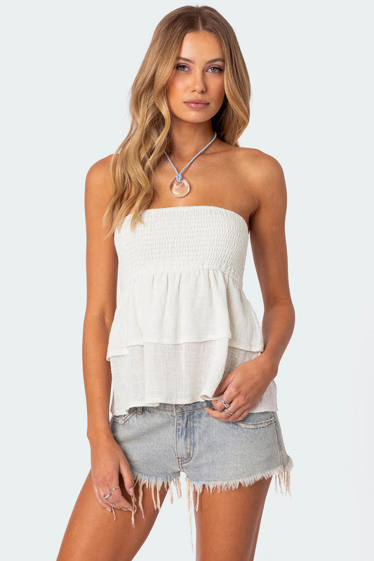 Femme portant un haut chic vanillagirl blanc sans bretelles avec jupe en jean délavée